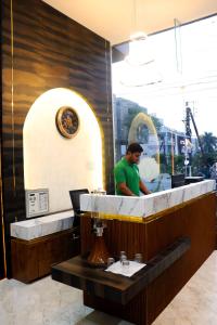 a man standing behind a counter at a restaurant at Hotel Pravasa Stay, Dewas Naka in Indore +48 photos