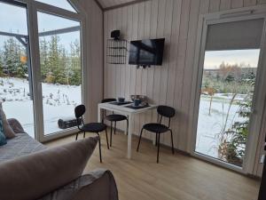 a living room with a table and chairs and a tv at Trzy Sówki in Ryki