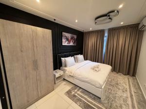 a bedroom with a white bed and a closet at Gem of Loxwood in Accra +67 photos