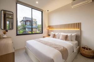 ein Schlafzimmer mit einem großen weißen Bett und einem Fenster in der Unterkunft Private Villa Ayra 8C by OriVista 10mins to Melasti Beach in Uluwatu + 18 Fotos