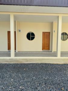 Ban Pak NgamにあるThe New Motelの二つのドアと窓のある建物 +1枚の写真