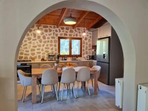 a kitchen with a table and chairs in a kitchen at Iriti's Villa & Dahlia Studio in Platanidia