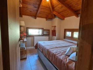 a bedroom with a large bed in a room with wooden ceilings at Iriti's Villa & Dahlia Studio in Platanidia +133 photos