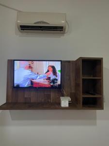a flat screen tv sitting on top of a wall at Flat Studio em Área central com ar condicionado e Garagem in Mogi das Cruzes