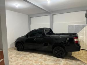a black car parked in a garage with the open trunk at Flat Studio em Área central com ar condicionado e Garagem in Mogi das Cruzes