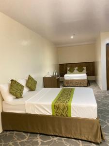 Rúm í herbergi á Maxi Hotel and Event Center