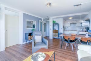a kitchen and living room with a table and chairs at Appartementencomplex Juliana 78 in De Koog