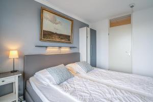 a bedroom with a bed and a picture on the wall at Appartementencomplex Juliana 78 in De Koog