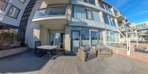 a balcony of a building with a table and chairs at Appartementencomplex Juliana 78 in De Koog +3 photos