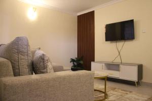 a living room with a couch and a flat screen tv at The Royal Residence in Kitengela 