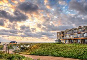 a building on top of a hill next to the ocean at Appartementencomplex Juliana 78 in De Koog