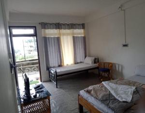 a bedroom with a bed and a couch and a window at Rishop Ridge Homestay By StayApart in Rishop