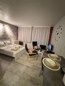 Una sala de estar con una cama, una mesa y sillas. en Petit Nid Nature Et Douceurs, en Turckheim