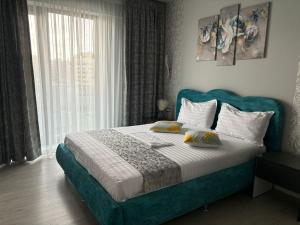 a bedroom with a bed with a blue headboard and a window at Alecsa 1 Luxury Residence in Mamaia