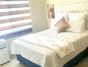 a bedroom with a white bed with a window at Mya Villa 2 in Fourways