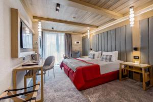 a bedroom with a bed and a desk in a room at Alpin Resort Hotel in Poiana Brasov