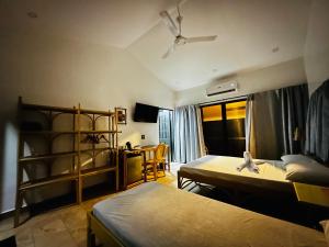 a bedroom with two beds and a room with a fan at Seaview Moonrise Café in Alcoy