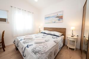 a bedroom with a bed with a white bedspread at Beachfront villa Mihovil with direct beach access in Kastel Stafilic +42 photos