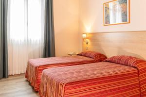 A bed or beds in a room at Hotel Ziò Imola