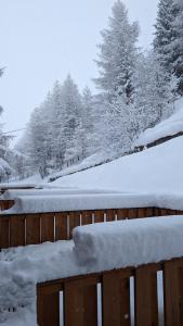 a fence covered in snow with trees in the background at Apartments in the woods in Pila