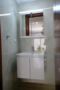 a white bathroom with a sink and a mirror at Eva House 1 in Drama