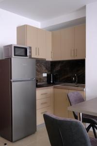a kitchen with a refrigerator and a table with chairs at Eva House 1 in Drama