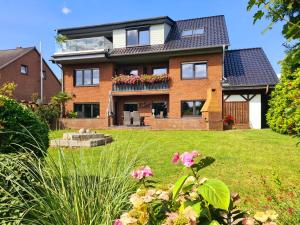 a large brick house with a yard with flowers at Haus Deepensoll 39 Ankerplatz in Pelzerhaken