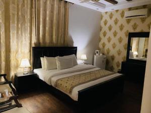 a bedroom with a large bed and a mirror at Hotel Imperial ByHI in Karachi