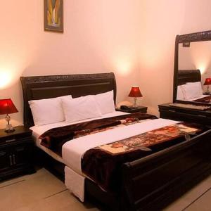 a bedroom with a large bed and a mirror at Hotel Imperial ByHI in Karachi
