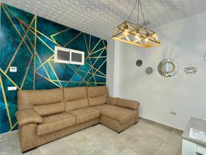 Una sala de estar con un sofá y un cuadro. en Suite la Bella, en Torre del Mar
