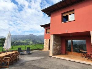 a building with a table and chairs and a umbrella at La Bergerie del Uncal VV-2915-AS in Arriondas