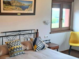 a bedroom with a bed and a window and a chair at La Bergerie del Uncal VV-2915-AS in Arriondas
