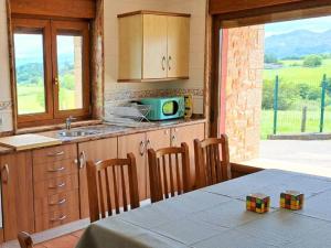 a kitchen with a table and a kitchen with a view at La Bergerie del Uncal VV-2915-AS in Arriondas