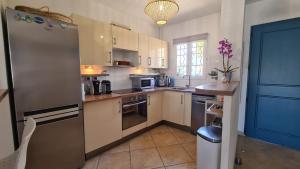 MARINA DEL SOL Aigues Mortes في إج مورت: مطبخ مع خزائن بيضاء وثلاجة