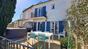 MARINA DEL SOL Aigues Mortes في إج مورت: طاولة وكراسي أمام منزل