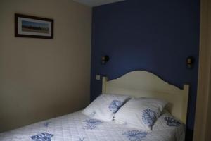 una camera da letto con un letto con una parete blu di appartement soustons plage a Soustons Altre 30 foto