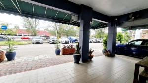 a parking lot with potted plants in a parking garage at Pine Lodge BY EVR Previously YSS indrawasih in Perai +12 photos
