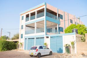 a white car parked in front of a building at Appartement familial chic et spacieux in Dassasgo