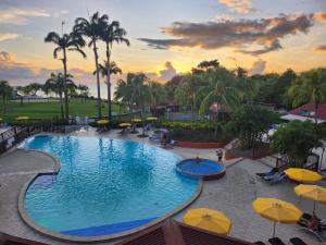 una piscina in un resort con ombrelloni di Ti coco luce studio à Sainte Luce dans village de vacances a Sainte-Luce