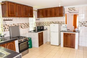 a kitchen with wooden cabinets and a white refrigerator at The π Homes in Eldoret