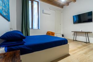 a bedroom with a bed with blue sheets and a tv at Al Merlo da Diego in Cagliari