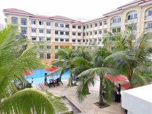a view of a hotel with palm trees and a pool at Aunt & Niece Condotel 2 Bedroom in Cebu City