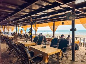 a group of people sitting at tables on the beach at Agonda Sunset Beach Resort in Agonda