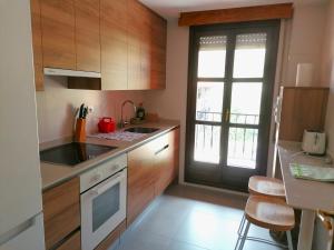 a kitchen with wooden cabinets and a sink and a window at Anatiduero in Molinos de Duero