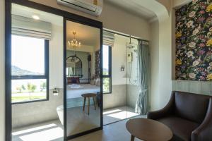 a living room with a chair and a table at Ang Pao Hotel Phuket in Phuket