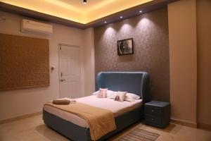 una camera da letto con un letto con testiera blu di Veetil -3BHK AC, Kukatpally, Hyderabad a Hyderabad