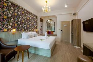 a hotel room with a bed and a wall mural at Ang Pao Hotel Phuket in Phuket