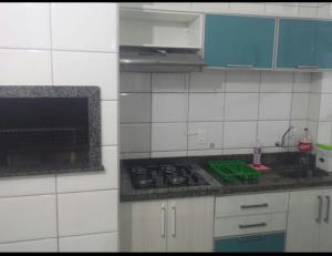 Una pequeña cocina con estufa y fregadero. en Costa Do Sol, en Guaratuba
