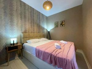 a bedroom with a bed and a table with a lamp at Perfect Place in Kutaisi