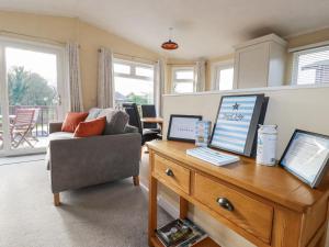 a living room with a couch and a desk with a laptop at Laurel Lodge in Tintagel